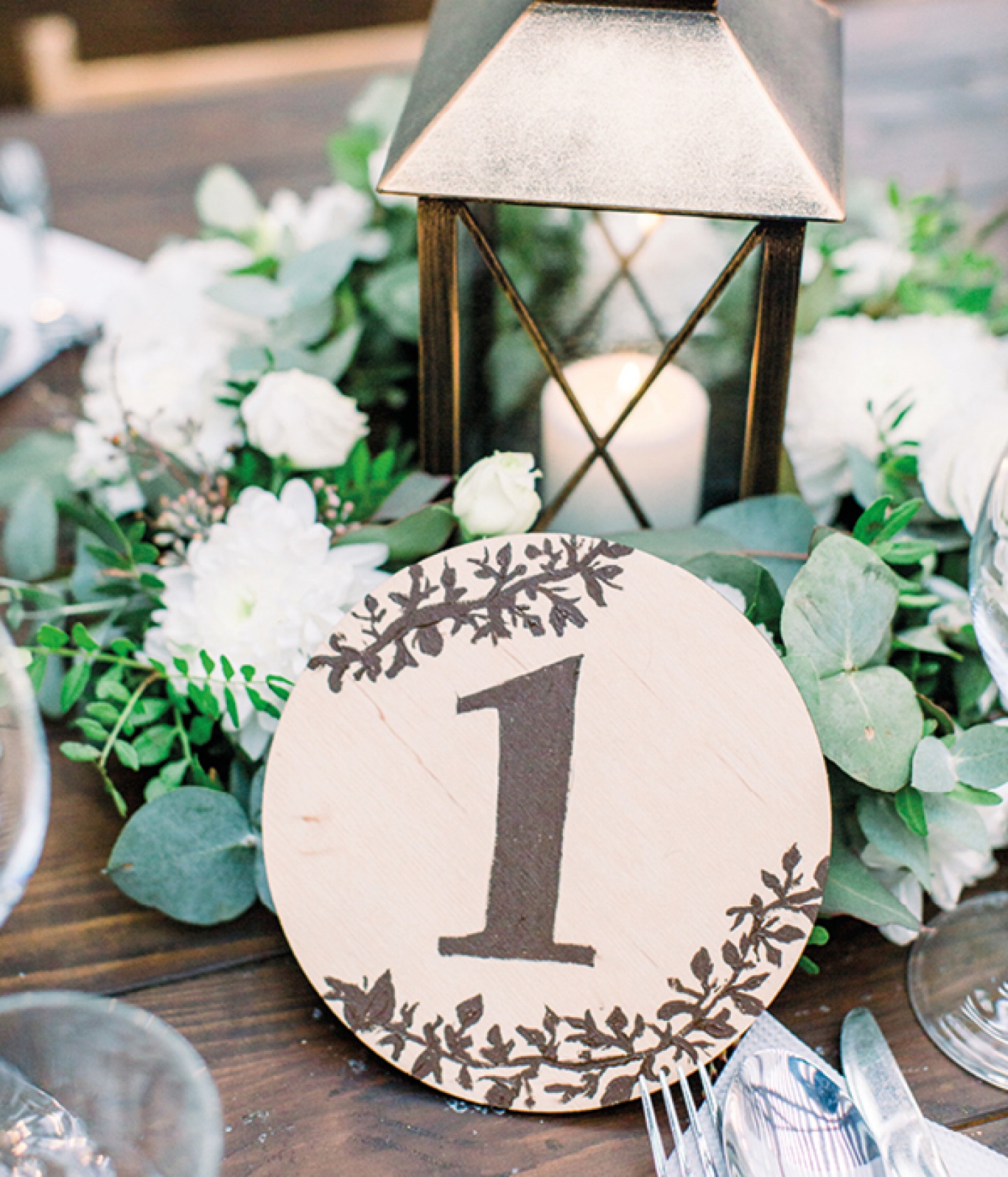 Number written on a card disc with flowers and lantern centrepiece