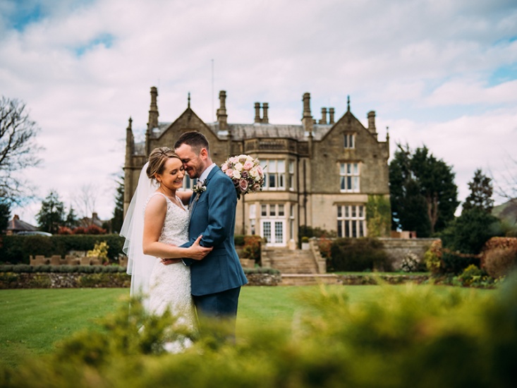 Couple embracing in the grounds of Falcon Manor on their wedding day