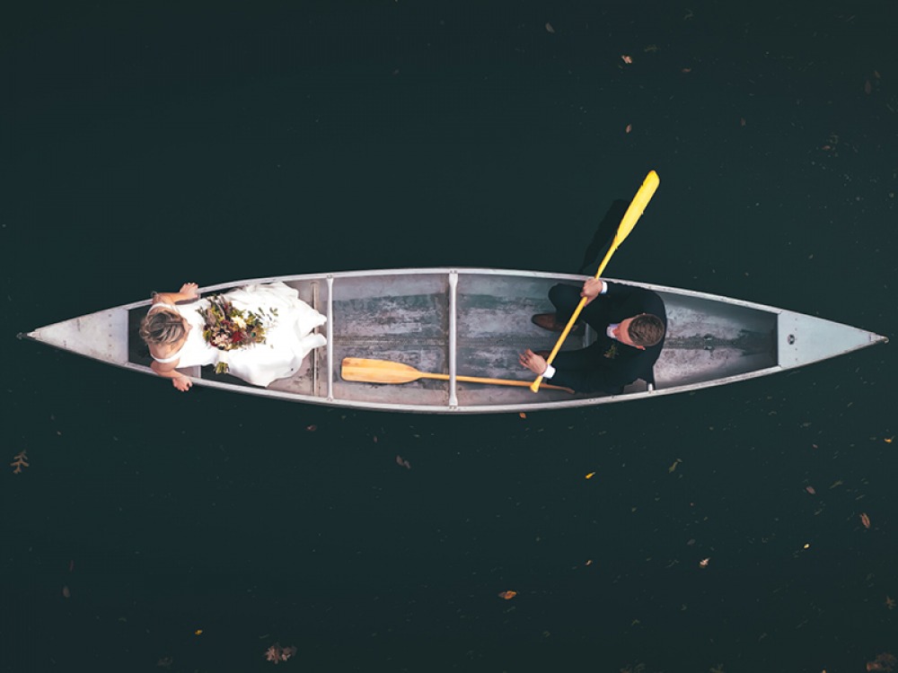 Ariel view of bride and groom in a rowing boat