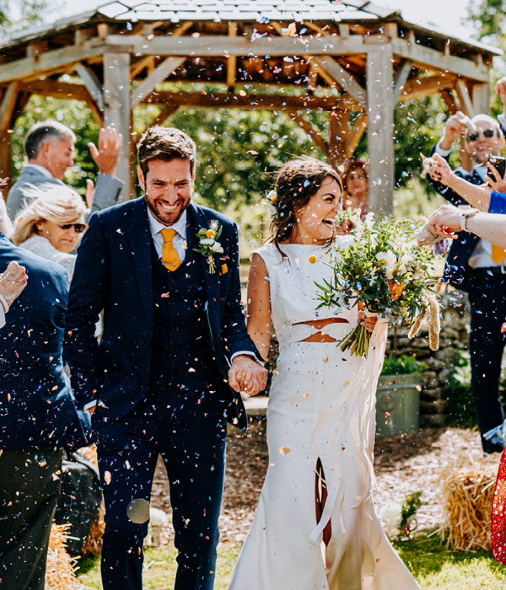 confetti being thrown over bride and groom