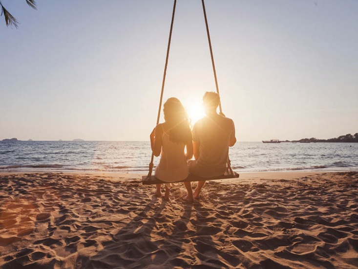 couple on beach swing