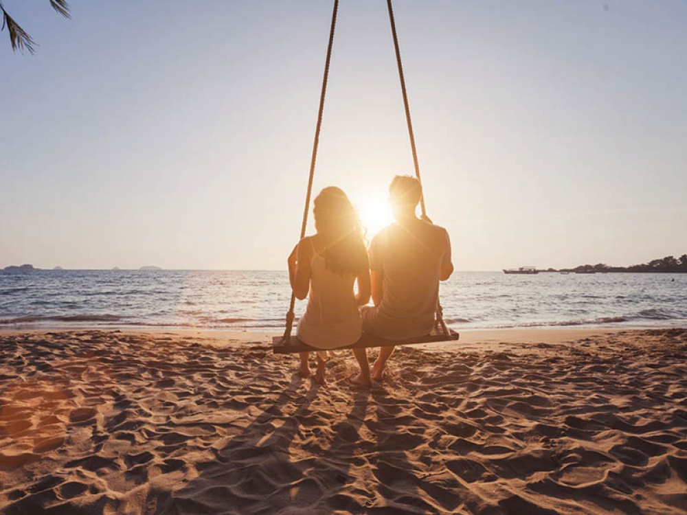 couple on beach swing