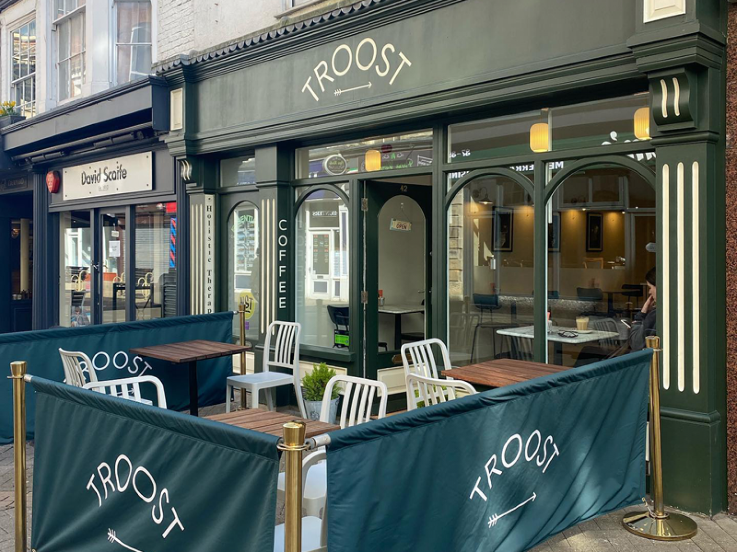 Green shop front with seats outside
