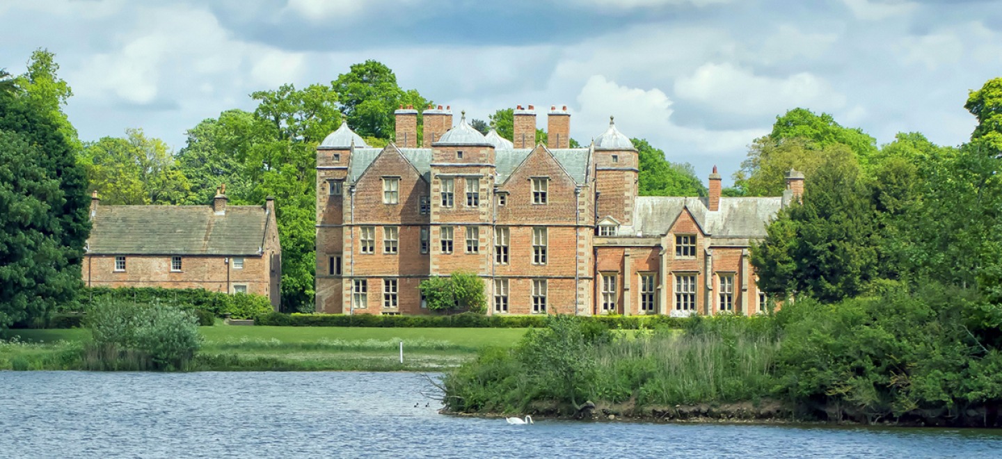 exterior of Kiplin Hall with lake at the front