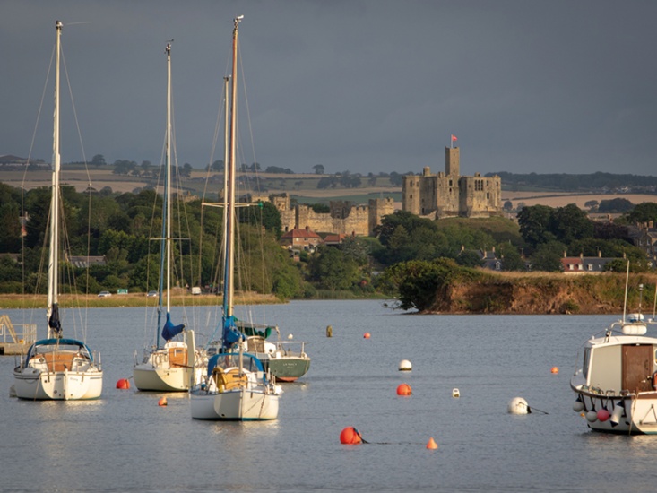 boats in a river with a castle in the background