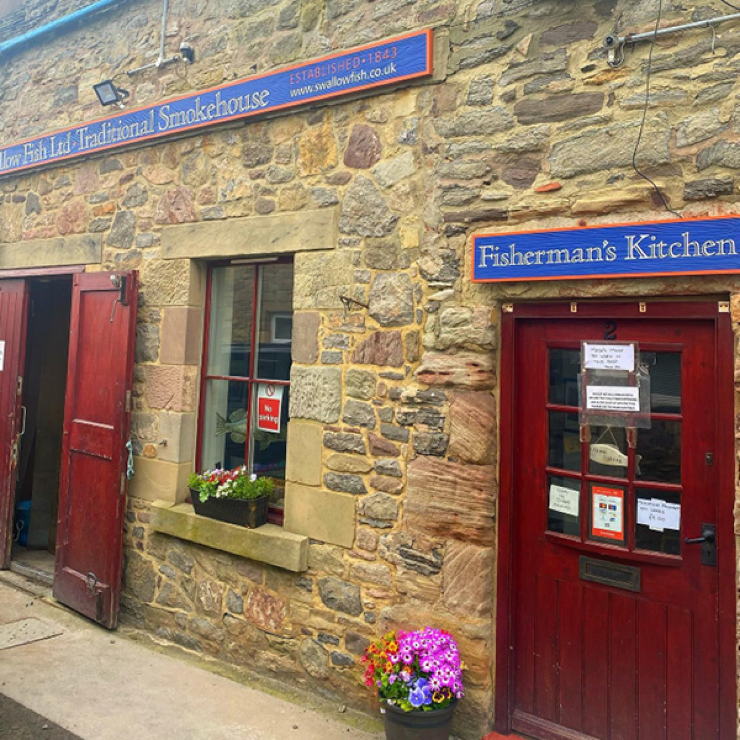 Shop front with flowers and a red door