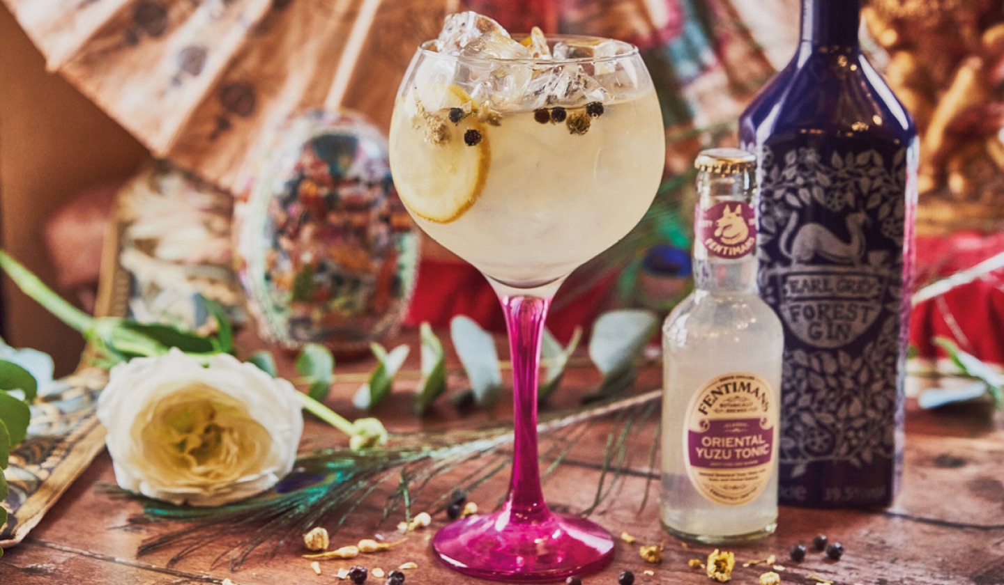 gin and tonic in pink steed glass photographed with props