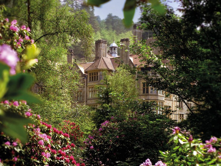 Cragside House surrounded by flowers and greenery