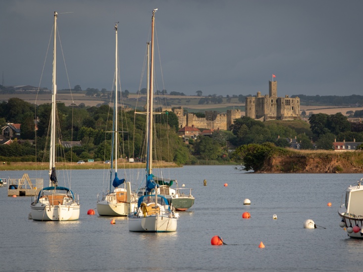 boats on a river with a castle in the background
