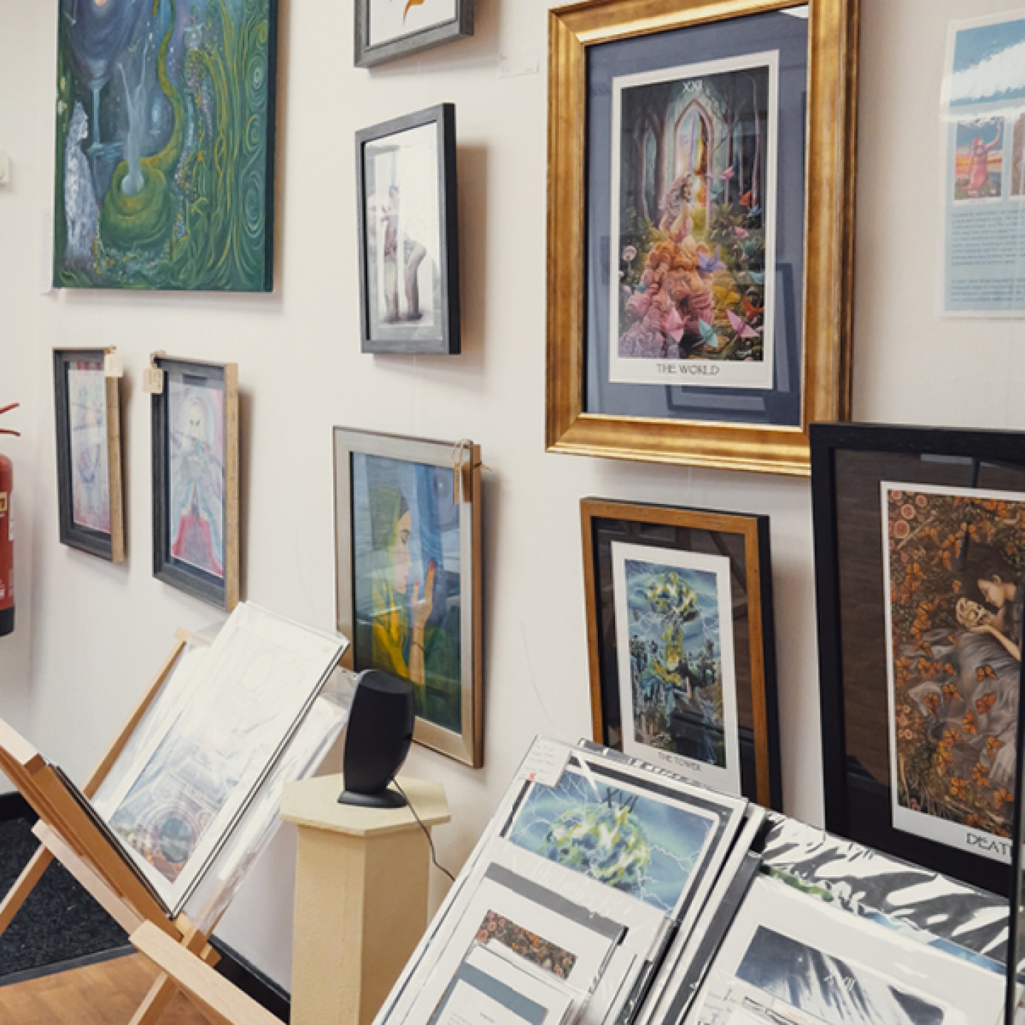 Paintings hanging and stacked at Creative Space