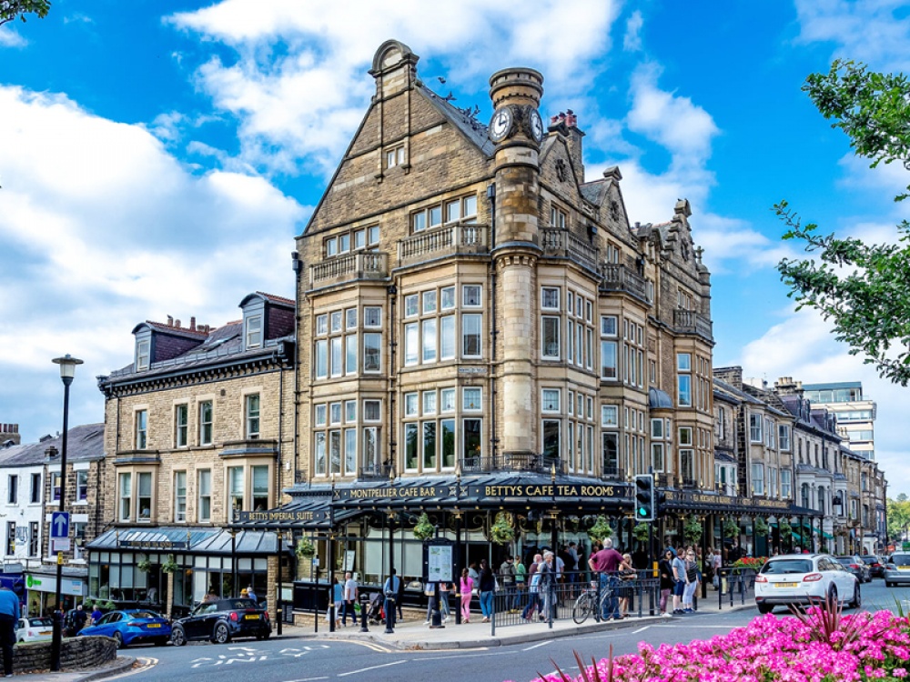 Corner building with a queue outside next to a busy road
