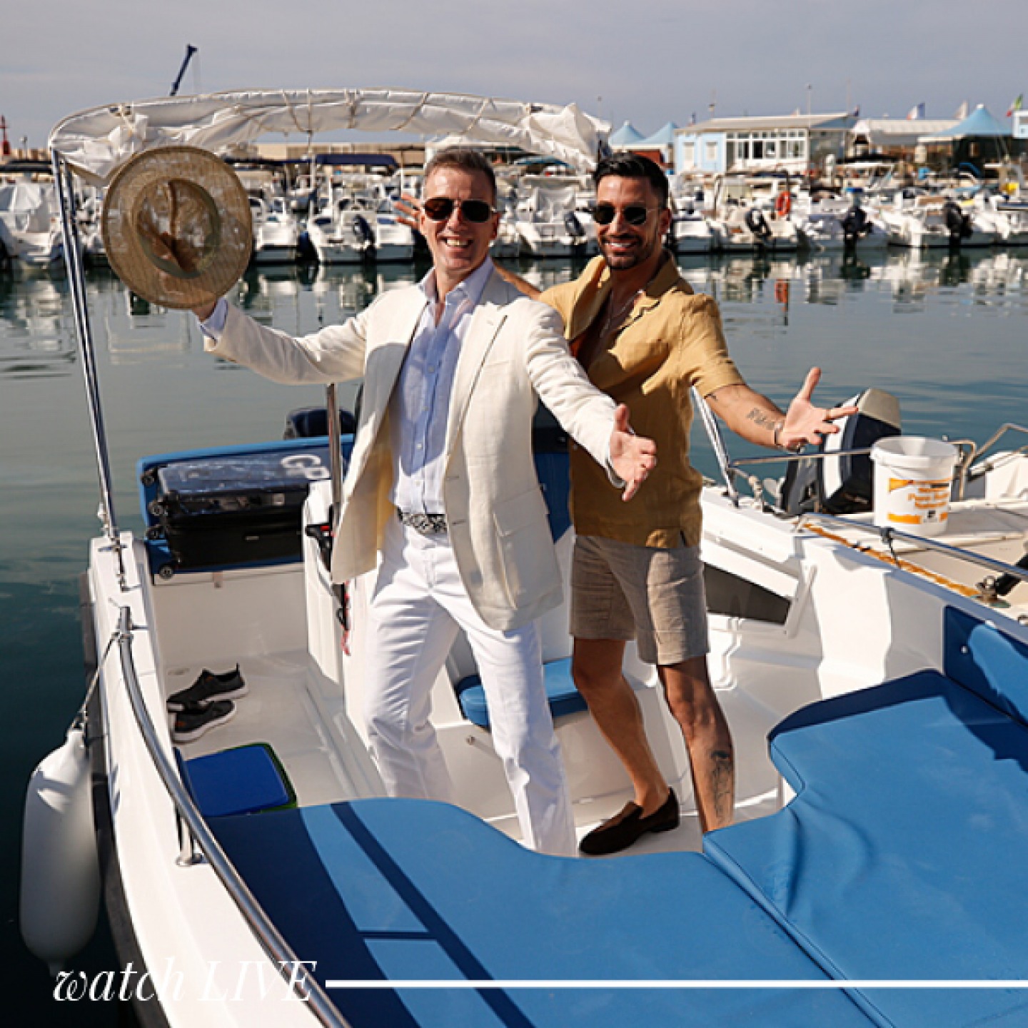 two men standing on a speedboat in the sunshine