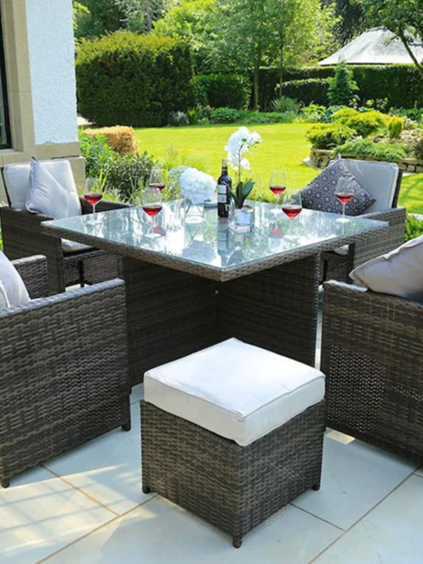 outdoor table with glasses of wine on it and chairs around