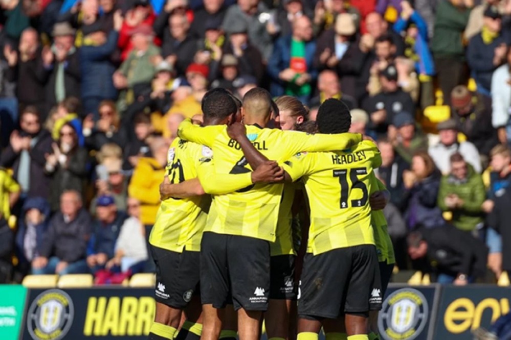 Harrogate players celebrating in a huddle