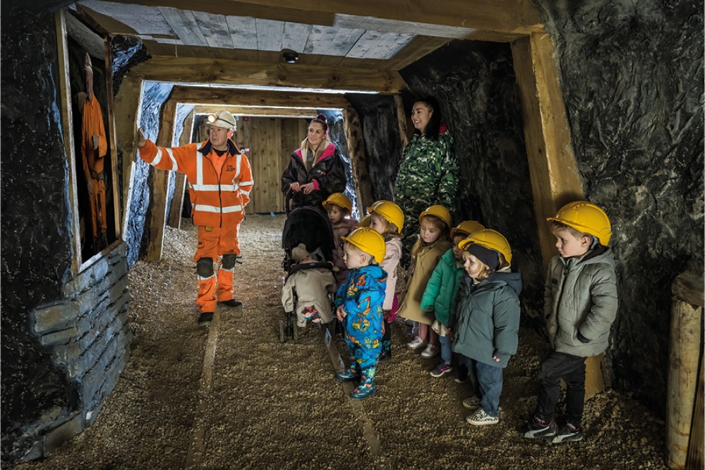 Kids visiting the tunnel wearing yellow hard hats