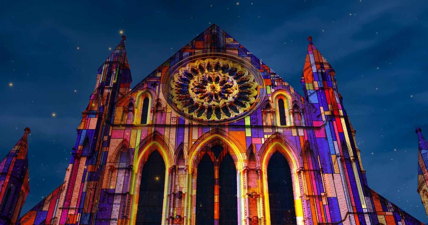 cathedral with lights projected on to it at night