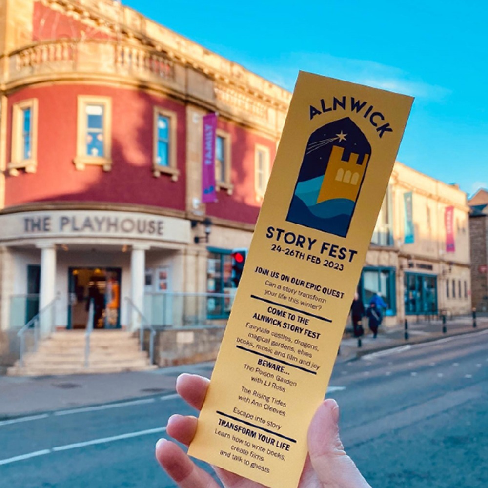 person holding a flyer about a book festival