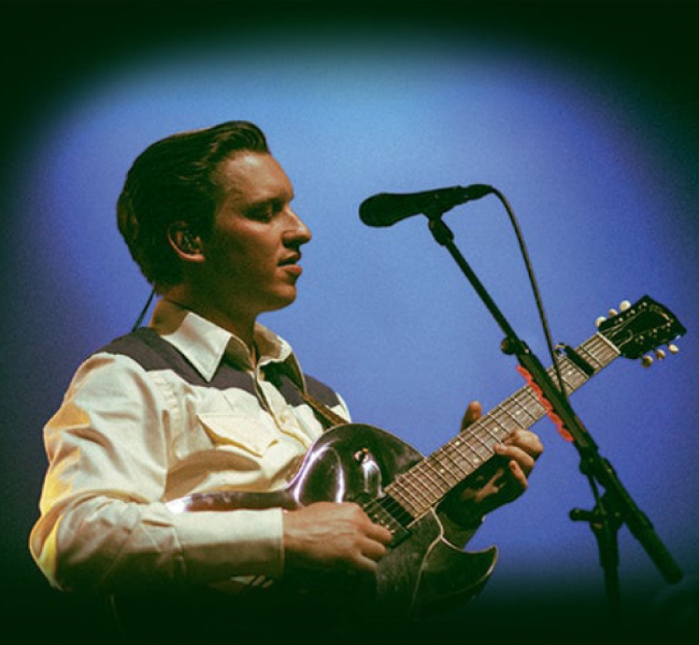 George Ezra playing a guitar and singing