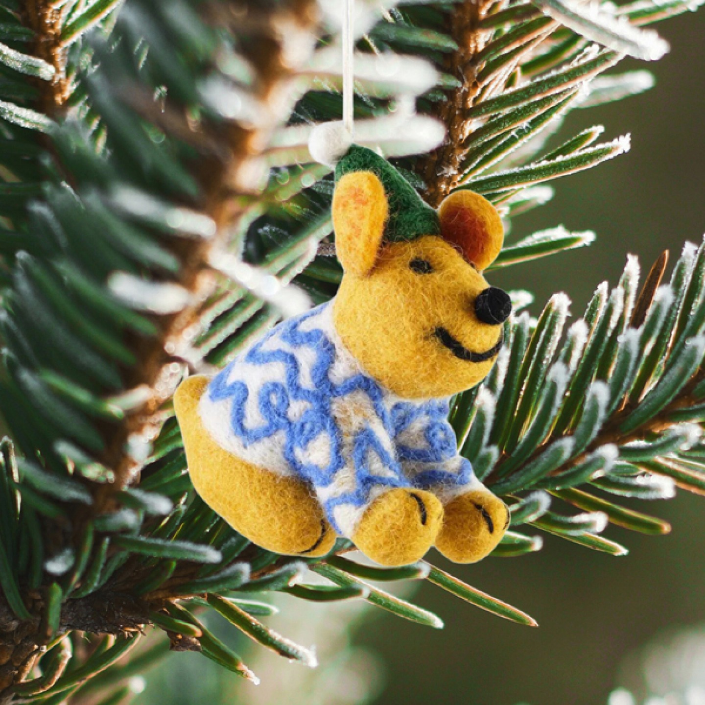Felt Christmas toy hanging from a pine branch