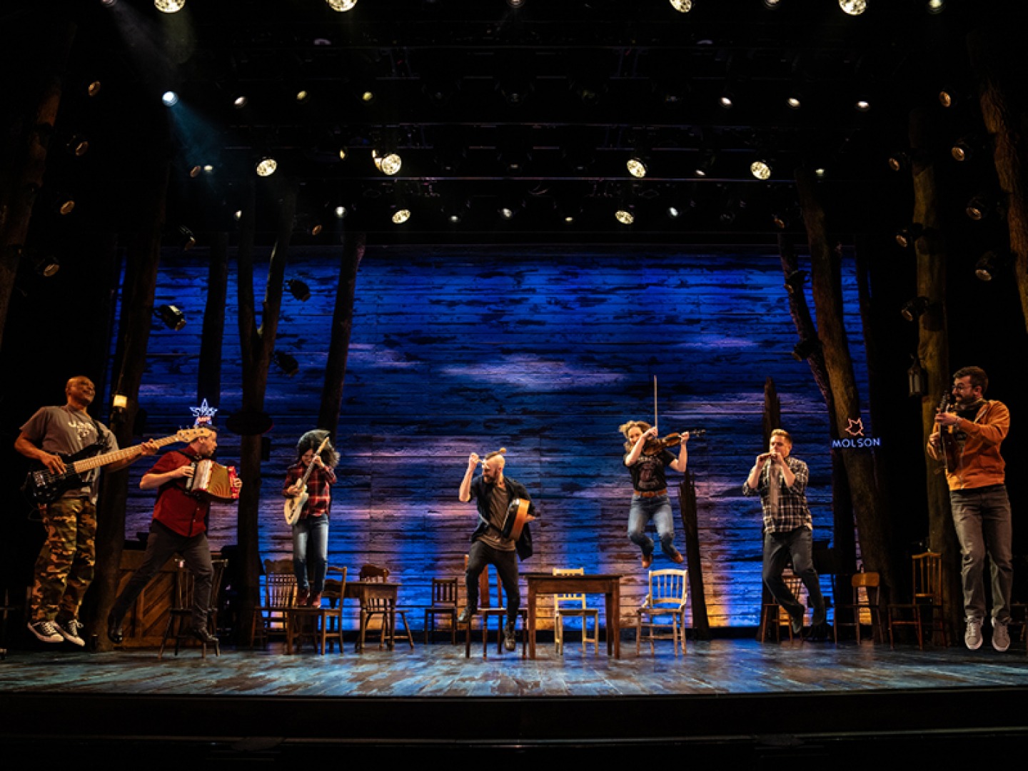 Cast members on stage playing musical instruments