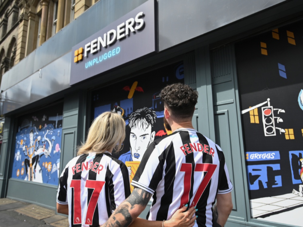 A blonde haired woman and a man looking at Fenders Unplugged