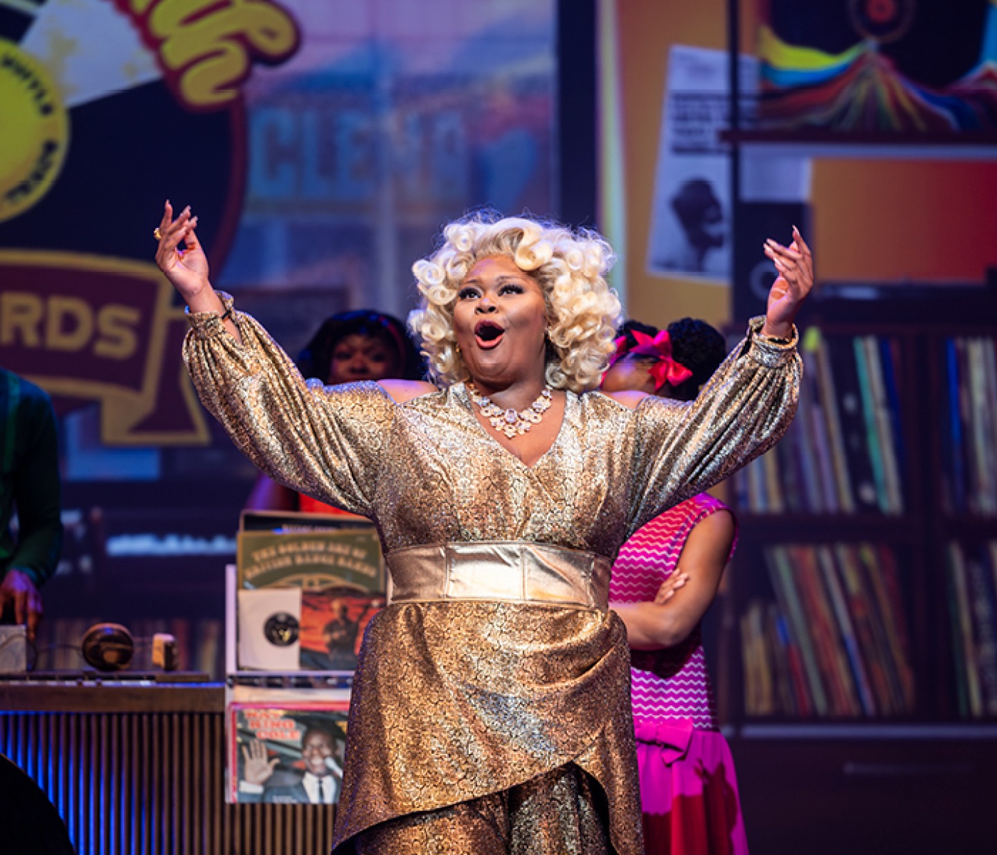 Ms Maybelle singing wearing a bold golden dress