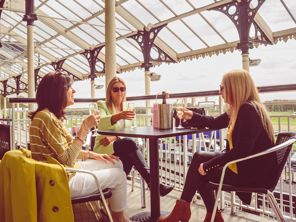 Visitor enjoying a glass of fizz on the terrace at Newcastle Race course during Living North Live