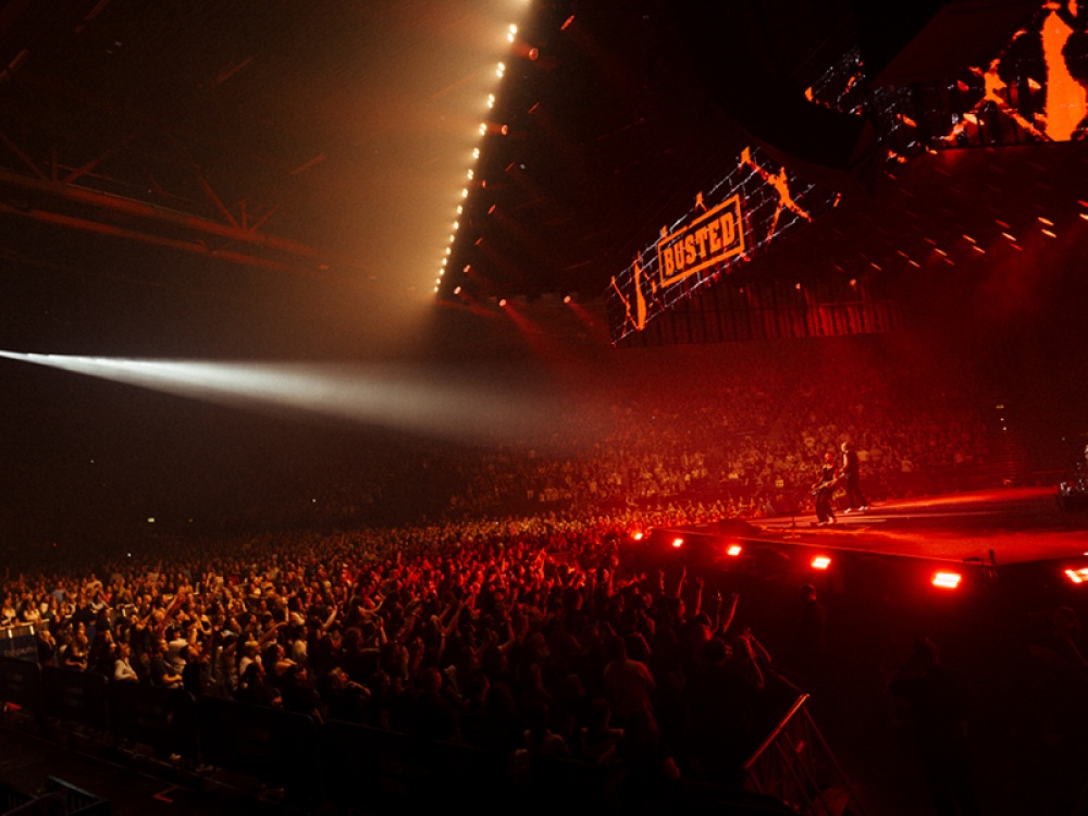 Busted on stage with red lighting affects and a cheering crowd