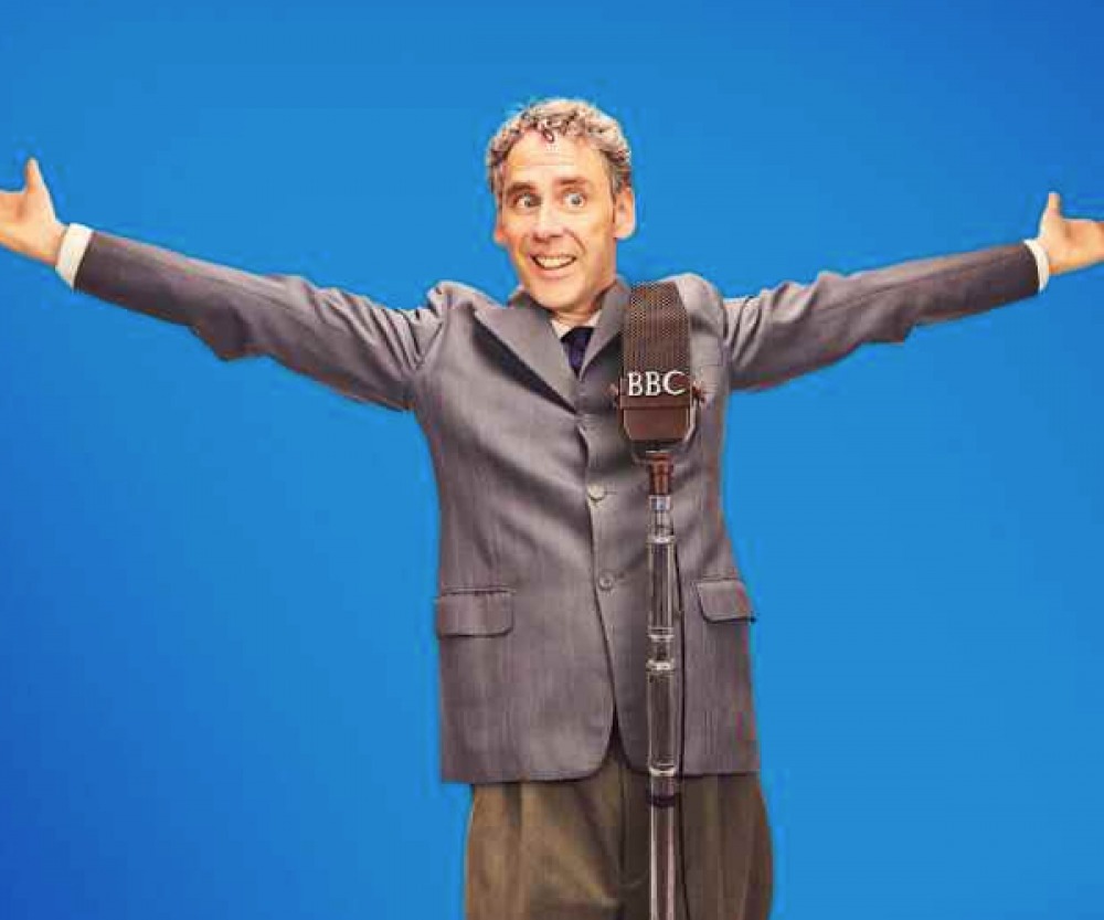 man standing with open arms behind a microphone