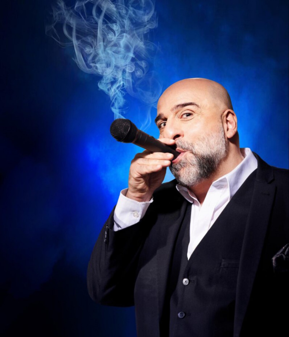 Omid Djalili pretending to smake a microphone