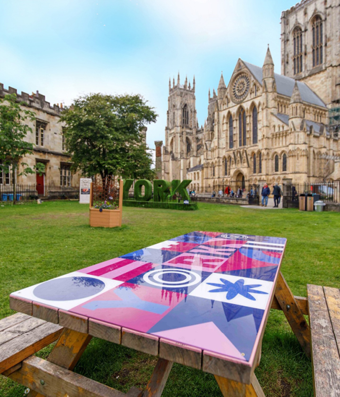 brightly coloured picnic bench on the green in front of York Minster