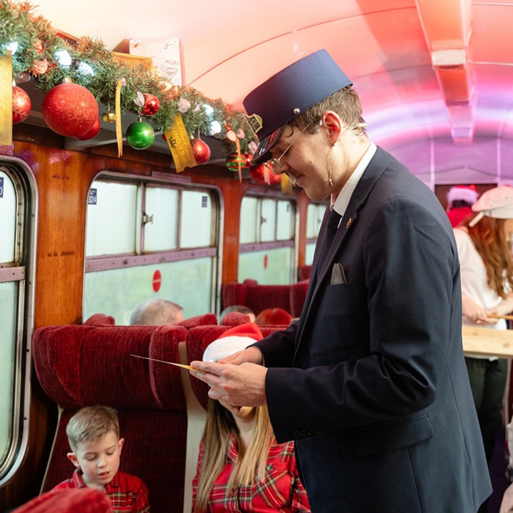The Polar Express Train with kids and a guard checking tickets