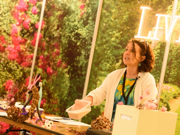 woman demonstrating how to make a spring wreath