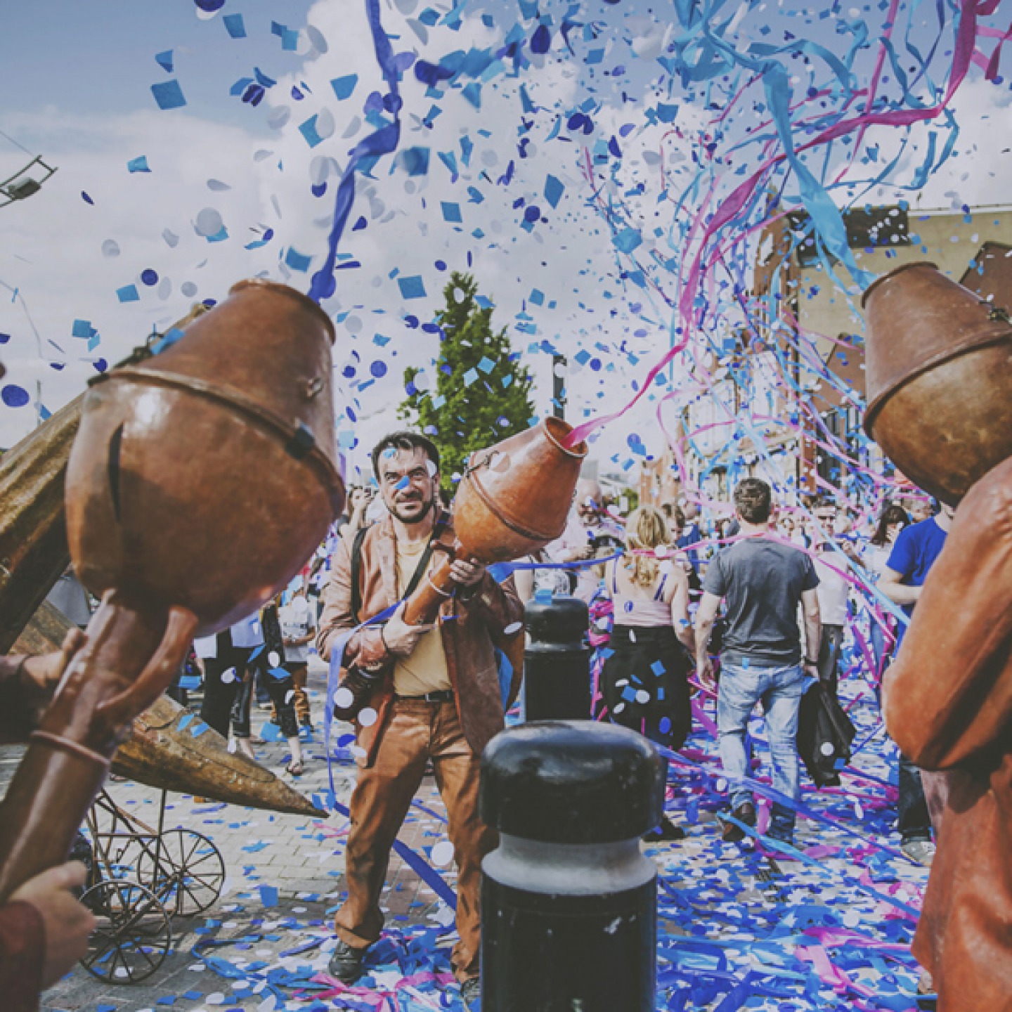 man holding confetti cannon surrounded by confetti and streamers