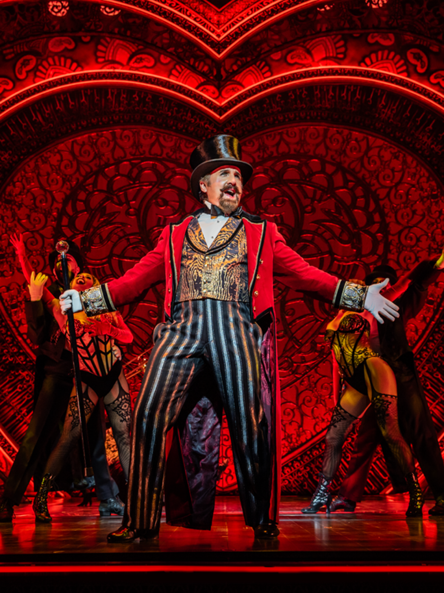 Cameron Blakely as Harold Zidler and the original world tour company of Moulin Rouge! The Musical. Photo credit – Johan Persson