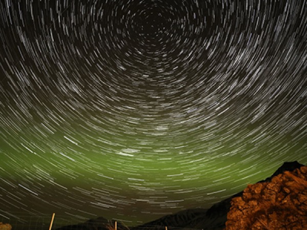 image of stars moving over the night sky with the northern lights