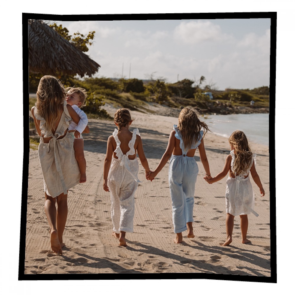 family of girls walking along the beach