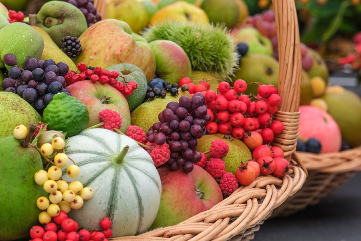 Wicker basket of berries, apples and squash