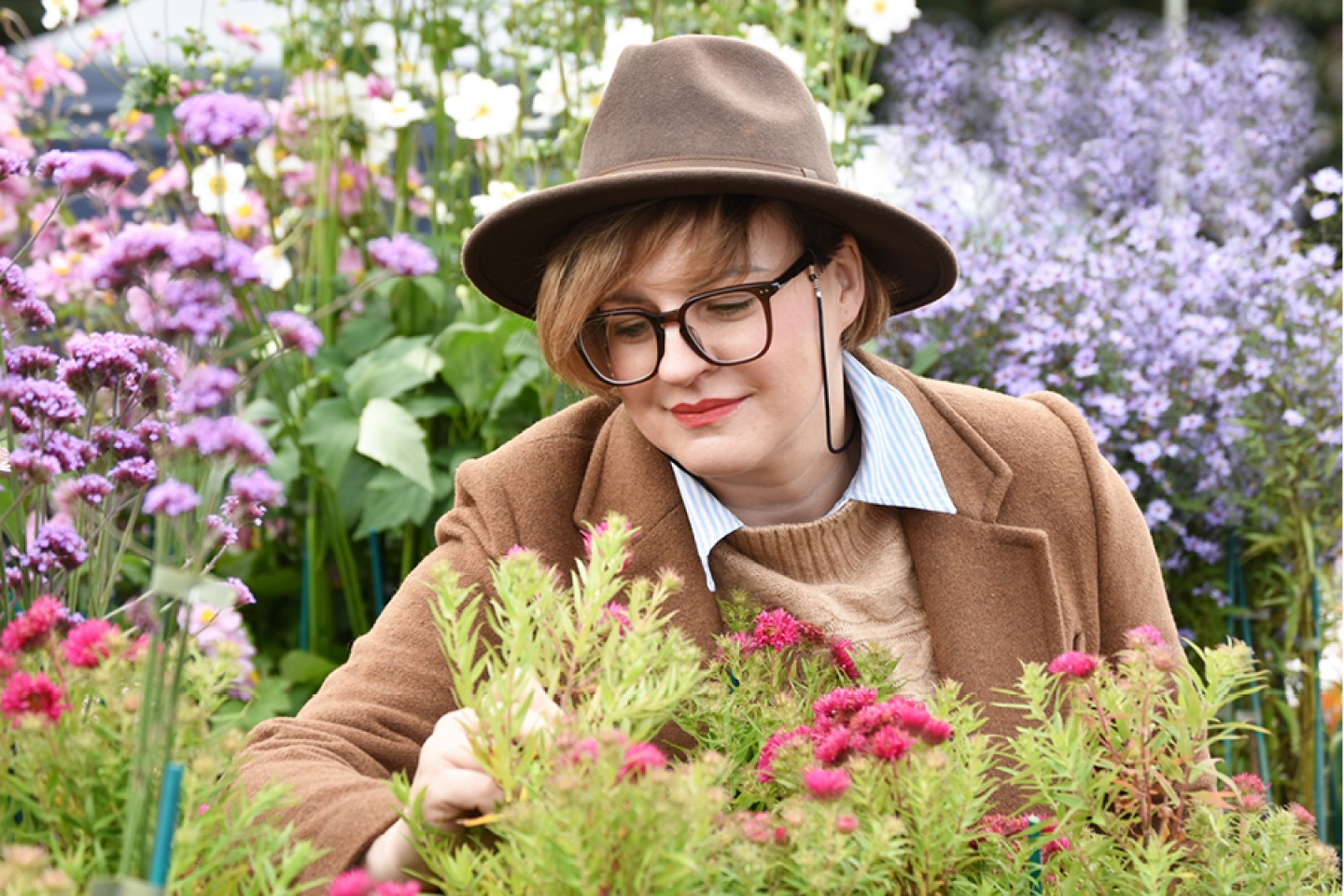 Visitor in a felt fedora browsing flowers