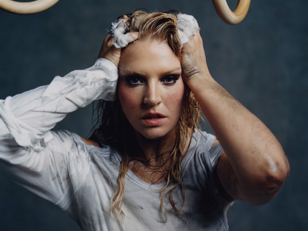 Self Esteem with soap in her hairs holding her head