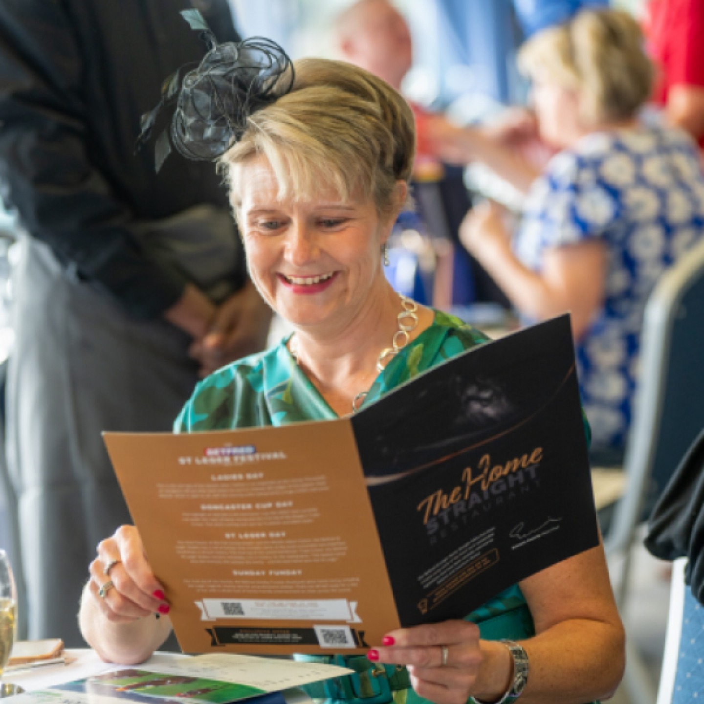 Lady reading the menu in a hospitality suit at the races